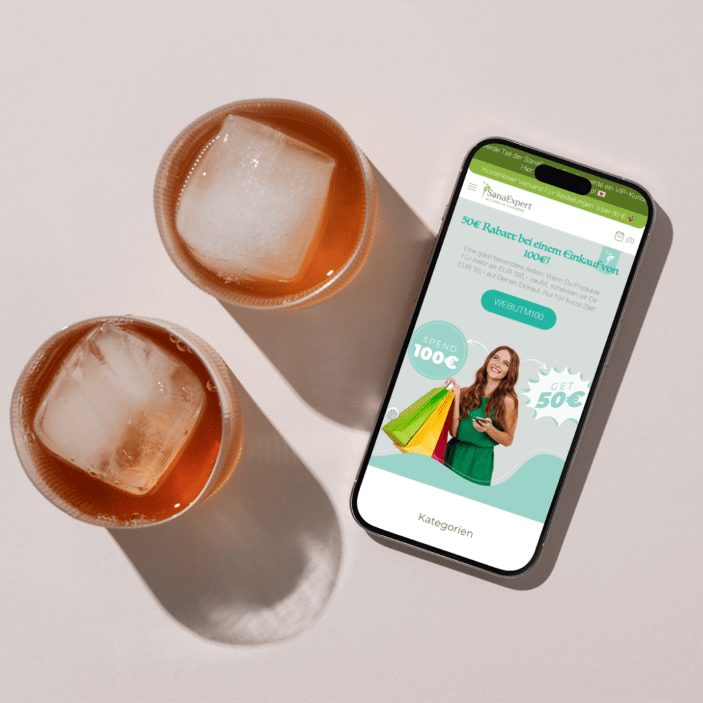 Mobile mockup of SanaExpert’s website displayed on a table next to two drinks, highlighting a €50 discount promotion.