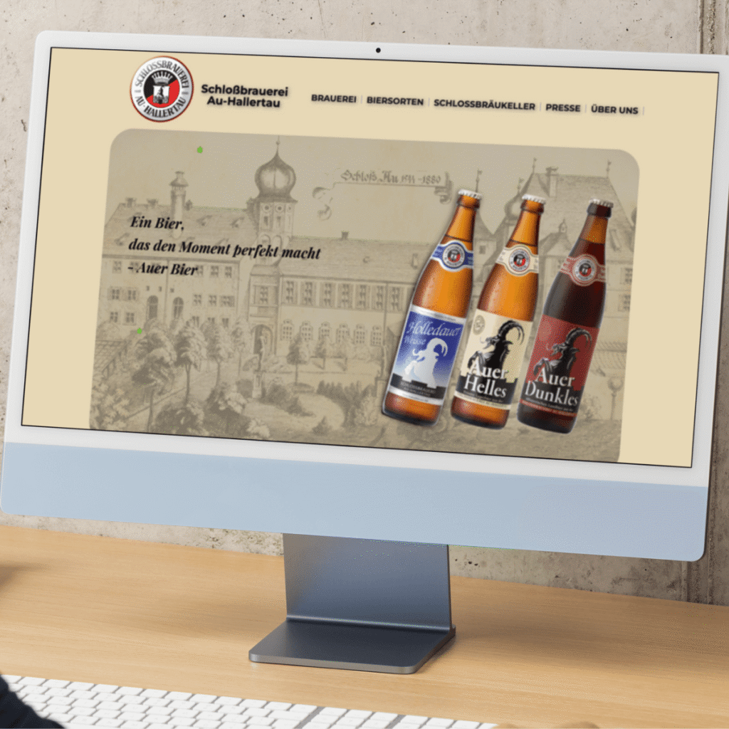 Desktop mockup of the Schlossbrauerei Au-Hallertau website displayed on an iMac, showcasing the homepage with hero banner and navigation menu.
